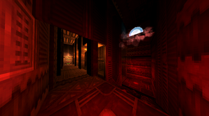 A gray room lit up red. A hole with a Soul Orb inside is past the door and above the room.