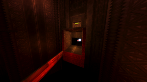 A red lit up room with a bottomless pit that has a platform in the middle, and entrances on both sides. Below the first entrance is a Soul Orb.